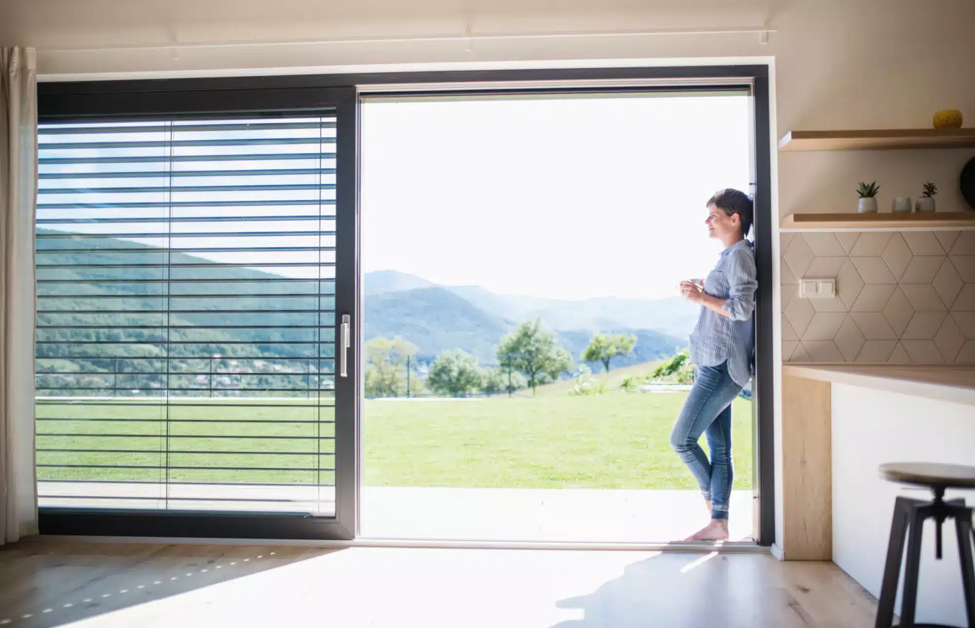 Stacking doors woman with coffee enjoying fabulous view